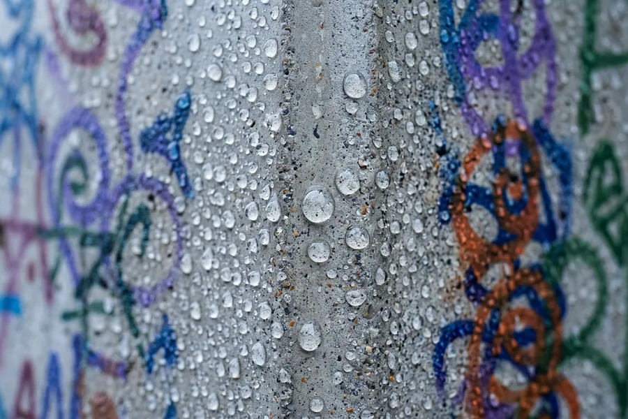 Wassertropfen perlen von einer beschichteten Betonwand ab